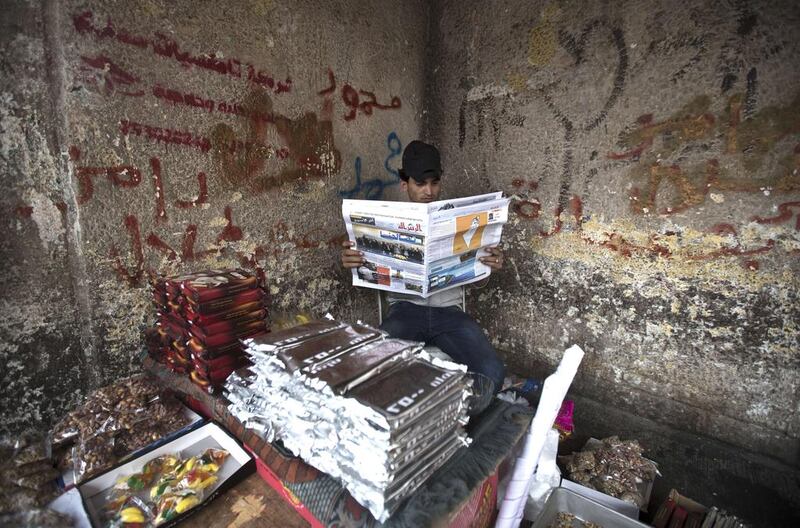 A Palestinian street vendor reads a newspaper the day after rival Palestinian leaders from the West Bank and Gaza Strip forged a new reconciliation agreement in Gaza City. Under the rapprochement between the Palestine Liberation Organisation and the Islamist Hamas which rules Gaza, the sides agreed to form a ‘national consensus’ government within weeks. Mohammed Abed / AFP Photo