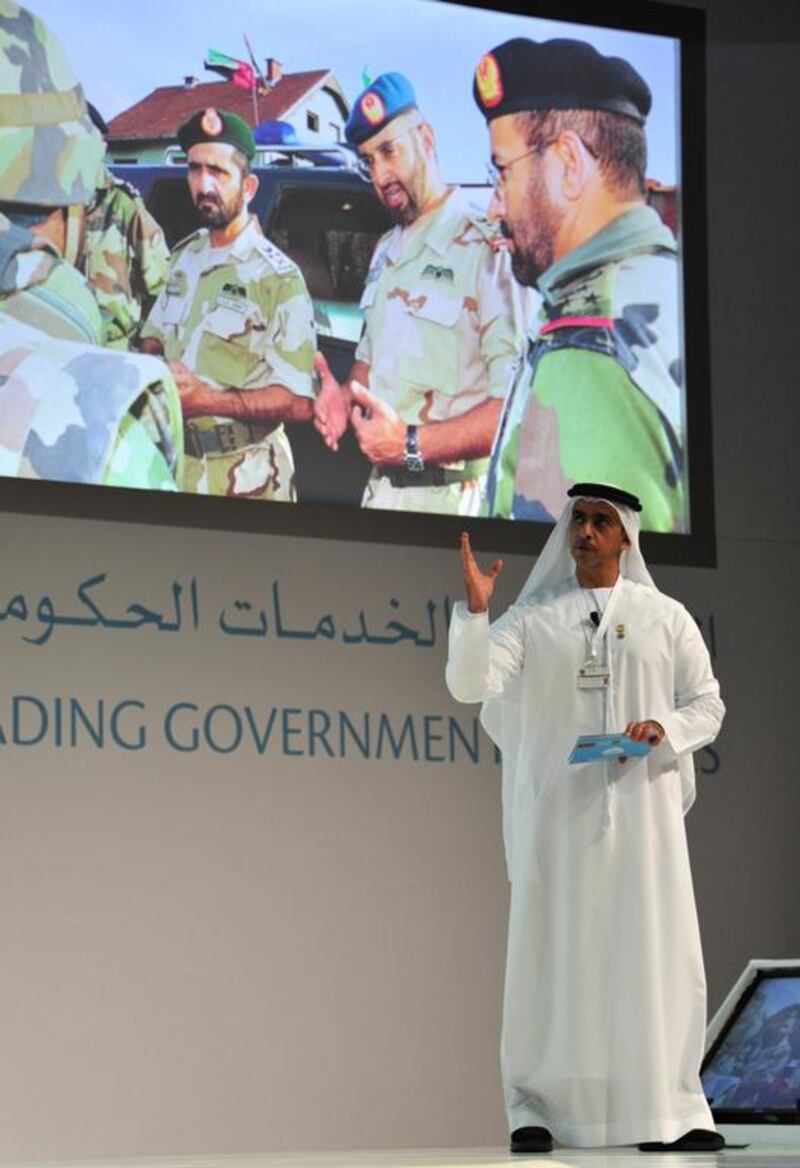 Sheikh Saif bin Zayed addresses the Government Summit yesterday against an archive photo backdrop of Sheikh Mohammed bin Rashid and Sheikh Mohammed bin Zayed on military duty. Courtesy Security Media