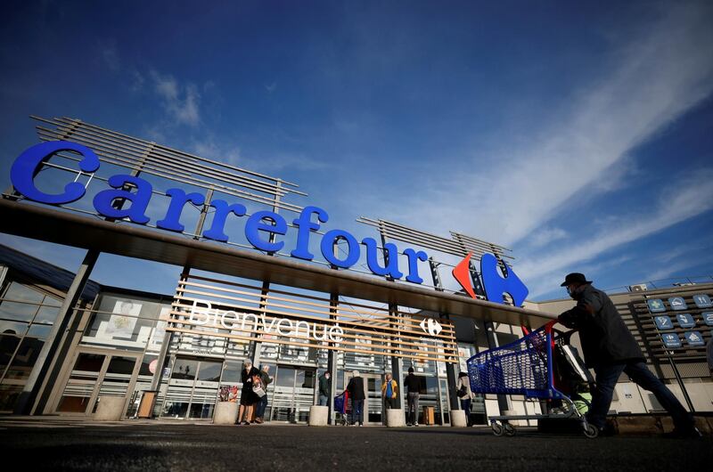 FILE PHOTO: A customer pushes his shopping trolley in front of a Carrefour Hypermarket store in Saint-Herblain near Nantes, France January 15, 2021. REUTERS/Stephane Mahe/File Photo