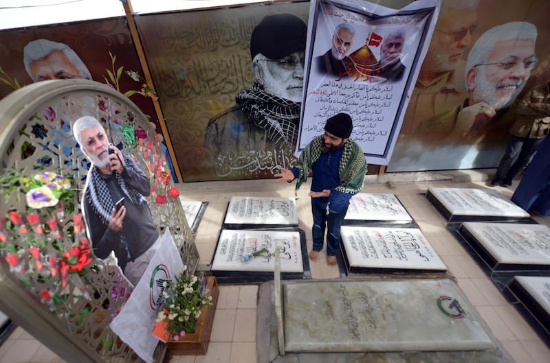 A man mourns at the grave of Iraqi paramilitary commander Abu Mahdi al-Muhandis, at the Wadi al-Salam ("Valley of Peace") cemetery in the Iraqi Shiite holy city of Najaf, on February 19, 2020. Al-Muhandis was killed alongside a top Iranian general in a US drone strike in Baghdad on January 3, and his final resting place in the world's largest cemetery has gained near-holy status, becoming an anti-US magnet and a stop for thousands of Shiite pilgrims who pass through Najaf each day to visit the tomb of Imam Ali, son-in-law of the Prophet Mohammed. / AFP / Haidar HAMDANI
