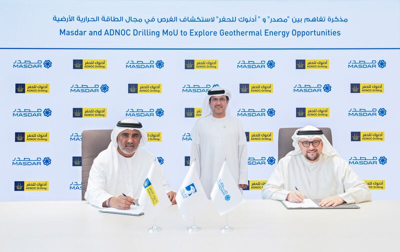 Adnoc executive Musabbeh Al Kaabi looks on as Adnoc Drilling's Abdulrahman Al Seiari and Masdar's Mohamed Al Ramahi sign the agreement. Photo: Adnoc