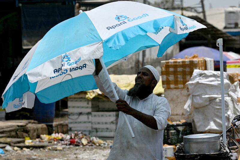 A man sets up a parasol for shade in New Delhi. The heatwave has been attributed to continuous dry weather in the second half of May. AFP