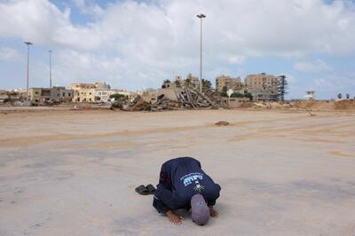 A man prays amid the destruction in Derna, Libya, after fatal floods were triggered by Storm Daniel in September. Many countries need major financial help to recover from and prepare for such climate-related disasters. Reuters