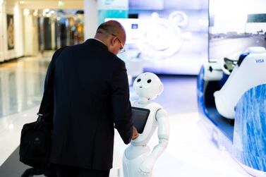 A visitor shakes hands with Pepper the robot in Dubai. The UAE's four main financial regulators jointly published a consultation paper on proposed new rules governing the use of technology in financial services. Reem Mohammed / The National