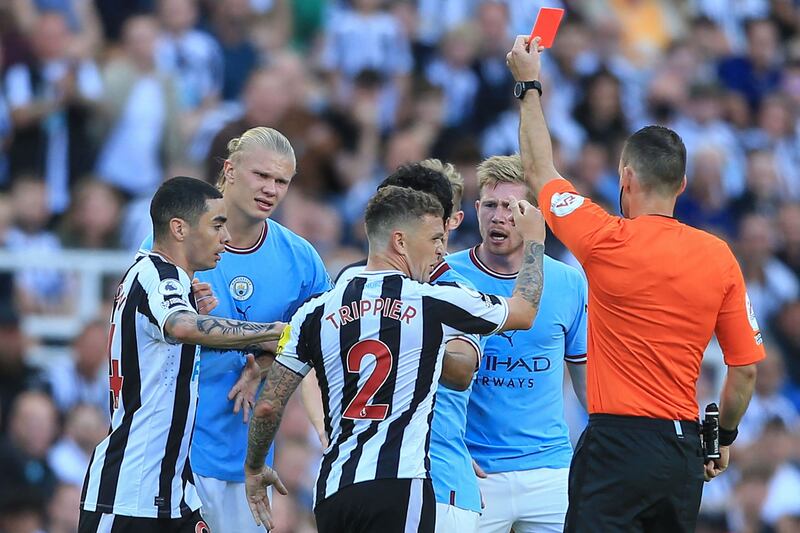 Referee Jarred Gillett shows a red card to Newcastle defender Kieran Trippier after he tripped Kevin de Bruyne. AFP