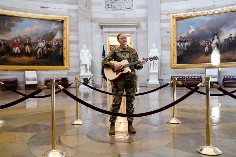 Michigan National Guard member Sgt Hannah Boulder sings while playing the guitar in the US Capitol Rotunda in Washington, US. Reuters