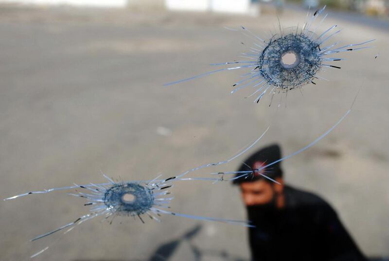 A Pakistani policeman seen through the damaged windscreen of a bullet-riddled Nato truck in Karachi. Asif Hassan / AFP