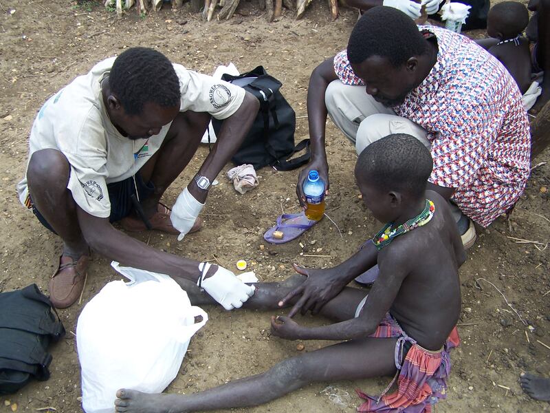 A health worker extracts a worm from a child's leg as Samuel Makoy Yibi, the national co-ordinator for the Guinea Worm Eradication Programme in South Sudan, assists.