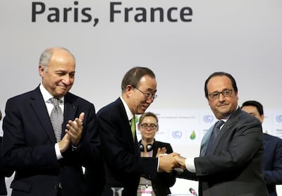 Cop21 President Laurent Fabius applauds as UN Secretary General Ban Ki-moon and French President Francois Hollande shake hands at the 2015 summit where the Paris Agreement was signed. Reuters