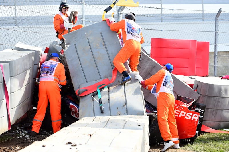 Course marshalls remove barriers from the top of Carlos Sainz of Spain and Scuderia Toro Rosso's damaged car after he crashed during final practice for the Formula One Grand Prix of Russia at Sochi Autodrom on October 10, 2015 in Sochi, Russia. Getty Images