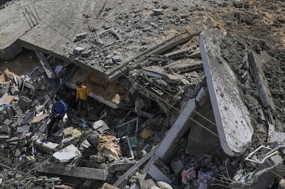 People survey the damage after an Israeli air strike destroyed a family home in Deir Al Balah on April 4. EPA