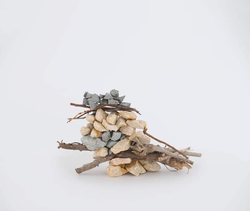 A relatively small prototype, on a table, of a misfit assembly wall incorporating stone and twigs. Photo: National Pavilion UAE La Biennale di Venezia / Basil Al Taher