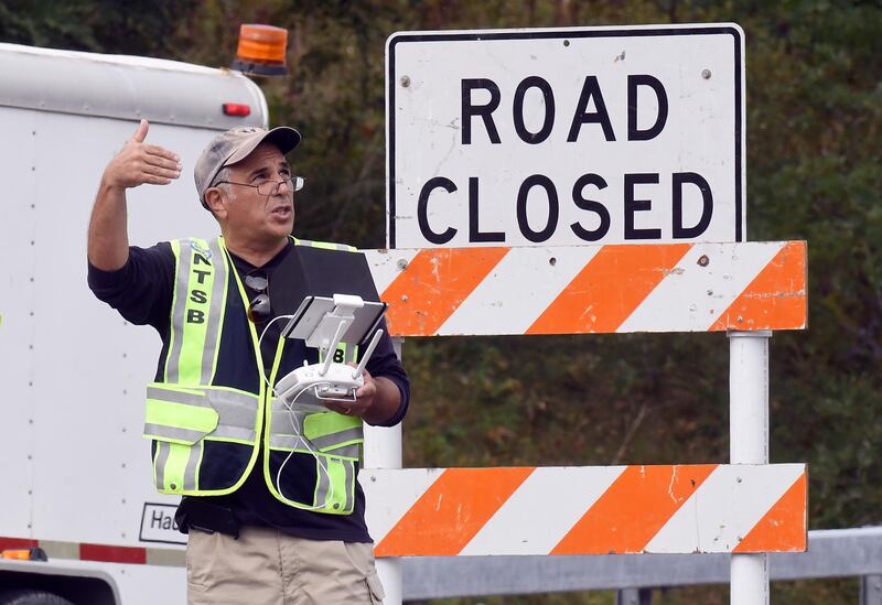 A drone operator with the National Transportation Safety Board conducts an investigation at the scene of Saturday's fatal limousine crash in Schoharie, N.Y., Monday, Oct. 8, 2018. A limousine loaded with revelers heading to a 30th birthday slammed into an SUV parked outside a store, killing all people in the limo and a few pedestrians. (AP Photo/Hans Pennink)