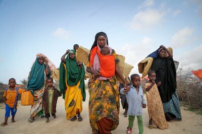 Somalis who fled drought-hit areas carry their belongings to a camp for the displaced, near Mogadishu, on June 30. AP