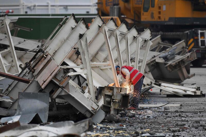 A worker cuts up steel during demolition of the Workers' Stadium in Beijing. AFP