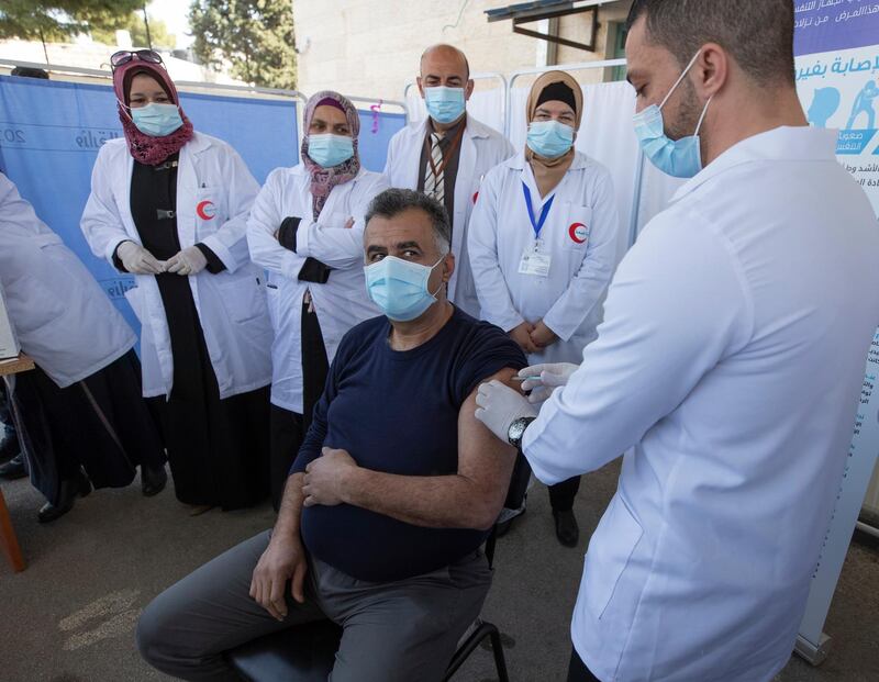 A medic administers a Moderna COVID-19 vaccine to a fellow medic during a campaign to vaccinate front-line medical workers, at the health ministry, in the West Bank city of Bethlehem, Wednesday, Feb. 3, 2021. The Palestinian Authority administered its first known coronavirus vaccinations after receiving several thousands of doses of the Moderna vaccine from Israel. The Pfizer-BioNTech and AstraZeneca vaccines will be provided in the coming weeks through COVAX, a World Health Organization program designed to help poor countries acquire vaccines. (AP Photo/Nasser Nasser)