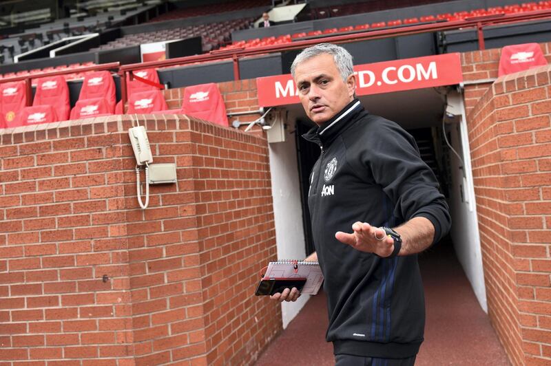 Manchester United's new Portuguese manager Jose Mourinho arrives to pose with a football shirt during a photocall on the pitch at Old Trafford stadium in Manchester, northern England, on July 5, 2016. - Jose Mourinho officially started work as Manchester United manager at the club's Carrington training base yesterday. The 53-year-old was appointed as United boss in May after the sacking of Dutchman Louis van Gaal. (Photo by OLI SCARFF / AFP)