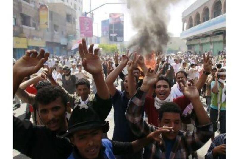 Anti-government protesters march near burning tyres during a demonstration to demand the departure of Yemen's President Ali Abdullah Saleh in the southern city of Taiz yesterday.