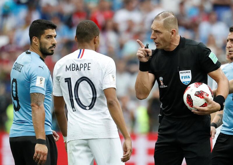 Soccer Football - World Cup - Quarter Final - Uruguay vs France - Nizhny Novgorod Stadium, Nizhny Novgorod, Russia - July 6, 2018  Referee Nestor Pitana speaks to Uruguay's Luis Suarez and France's Kylian Mbappe   REUTERS/Damir Sagolj