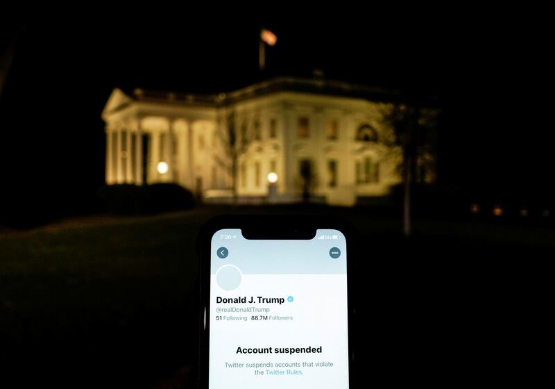 A photo illustration shows the suspended Twitter account of U.S. President Donald Trump on a smartphone and the White House in Washington, U.S., January 8, 2021.  REUTERS/Joshua Roberts/Illustration