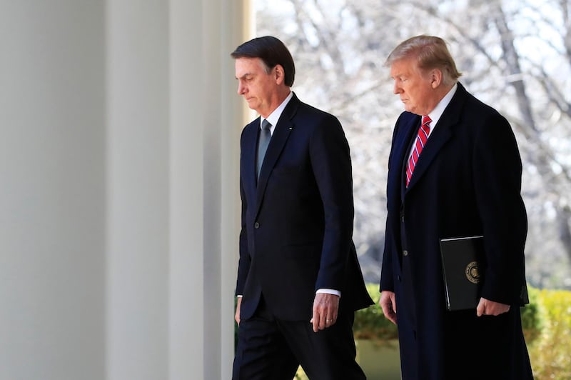 President Donald Trump and visiting Brazilian President Jair Bolsonaro walk along the Colonnade of the White House, March 19, 2019, in Washington. (AP Photo/Manuel Balce Ceneta)