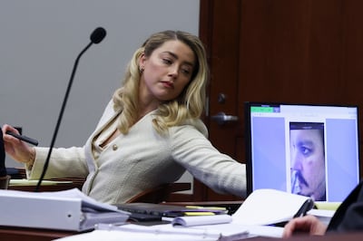 Actress Amber Heard listens to her former husband Johnny Depp, as a picture of an injury to his face is on a screen, during his defamation trial against her in Fairfax, Virginia. AFP