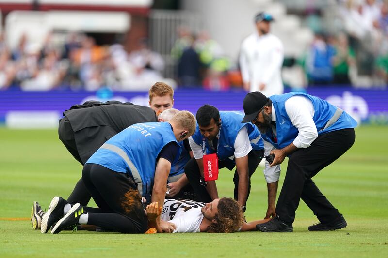 Security detain a Just Stop Oil protester during day one of the second Ashes Test. PA