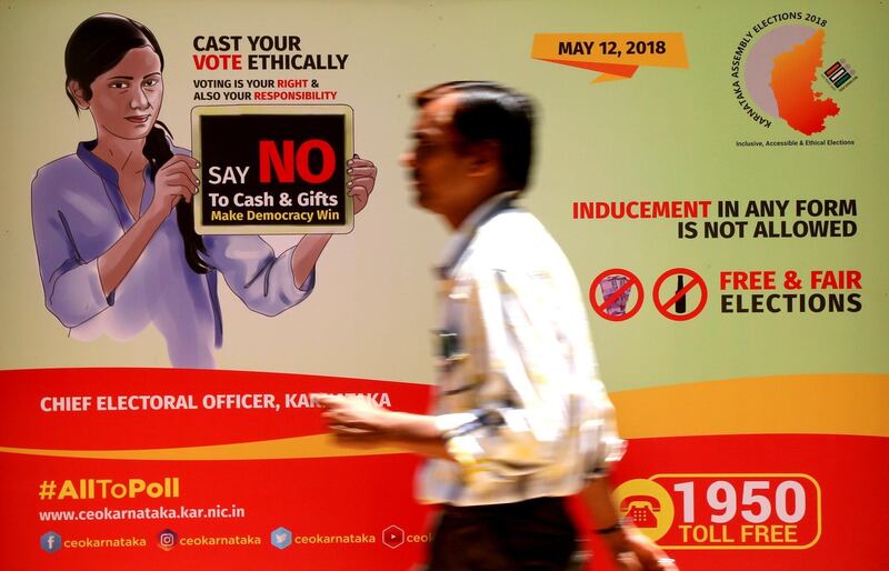epa06668562 A man walks in front of a billboard, on display to create awareness among people ahead of the Karnataka Legislative Assembly election in Bangalore, India, 14 April 2018. The election will be held in the southwest Indian state of Karnataka on 12 May 2018, in all of its 224 Legislative Assembly constituencies. Vote counting and results will be announced on 15 May 2018.  EPA/JAGADEESH NV