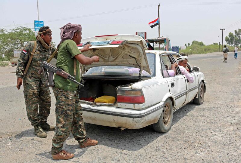 Fighters with the UAE-trained Security Belt Forces loyal to the pro-independence Southern Transitional Council (STC) search the trunk of a car at their checkpoint near the south-central coastal city of Zinjibar in south-central Yemen, in the Abyan Governorate, on August 21, 2019. 
 Yemeni separatists drove government troops out of two military camps in deadly clashes yesterday, reinforcing their presence in the south after they seized the de facto capital Aden. / AFP / Nabil HASAN
