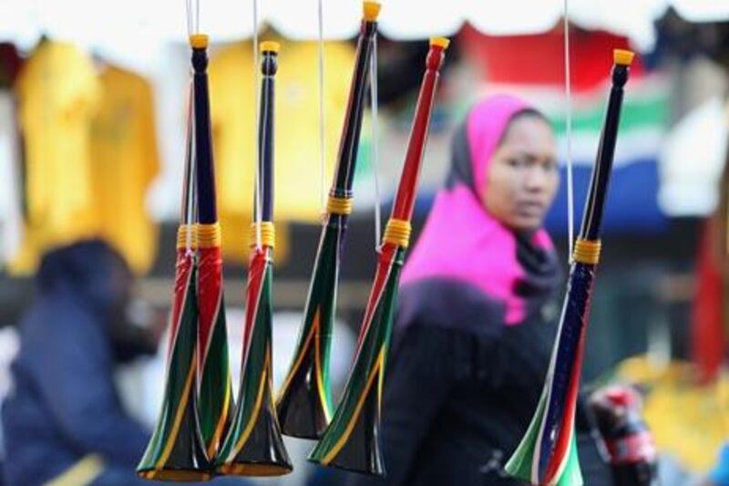 CAPE TOWN, SOUTH AFRICA - JUNE 08:  A woman woman walks past a stall selling Vuvuzelas in central Cape Town on June 8, 2010 in Cape Town, South Africa. The first World Cup ever held in Africa is due to begin in less than a week and the Vuvuzela has been causing controversy with some calling for the instrument to be banned.  (Photo by Dan Kitwood/Getty Images)