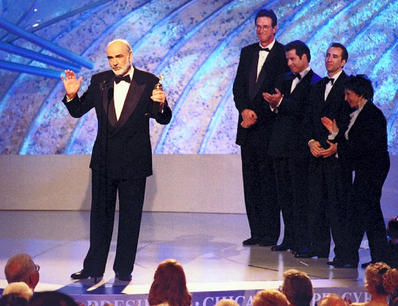 Actor Sean Connery (L) accepts the Cecil B. DeMille Award January 21 at the 53rd Annual Golden Globes Awards sponsored by the Hollywood Foreign Press Association in Beverly Hills, California telecast on NBC. Presenters shown at (R) Michael Crichton, John Travolta, Nicholas Cage and HFPA president Aida Takia O'Reily