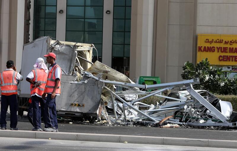 Several cars parked next to the entrance of the building were severely damaged, while other nearby vehicles also had minor damage. Pawan Singh / The National 