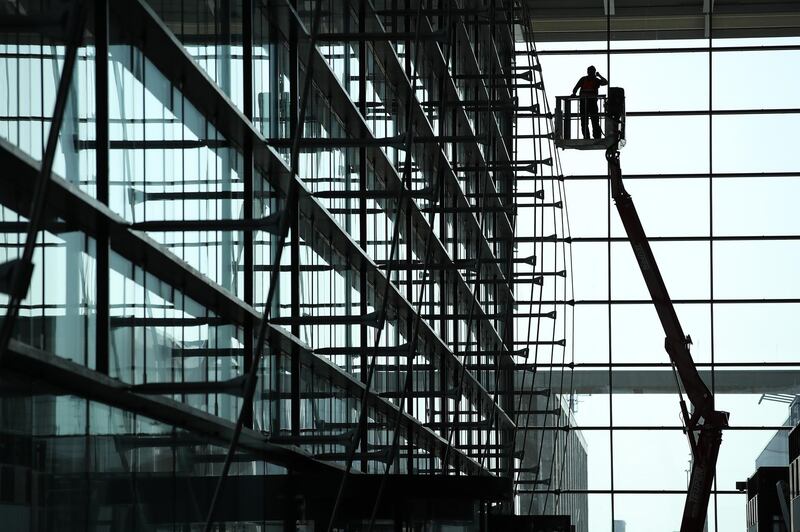 SCHOENEFELD, GERMANY - APRIL 10:  A worker stands on a raised platform inside the main departures hall at the BER Willy Brandt Berlin Brandenburg International Airport on April 10, 2018 in Schoenefeld, Germany. Originally scheduled to open in 2011, final completion of the new airport has been fraught with technical delays, construction design shortcomings, corruption scandals and other impedements. The most recent forecast is that the airport, which will serve Berlin, nearby regions and portions of western Poland, will finally begin full operation by 2021.  (Photo by Sean Gallup/Getty Images)