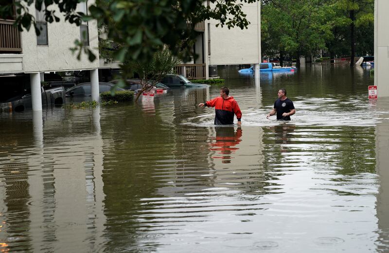 Men look for people wanting to be evacuated from the Hurricane Harvey floodwaters in Dickinson, Texas August 28, 2017. REUTERS/Rick Wilking