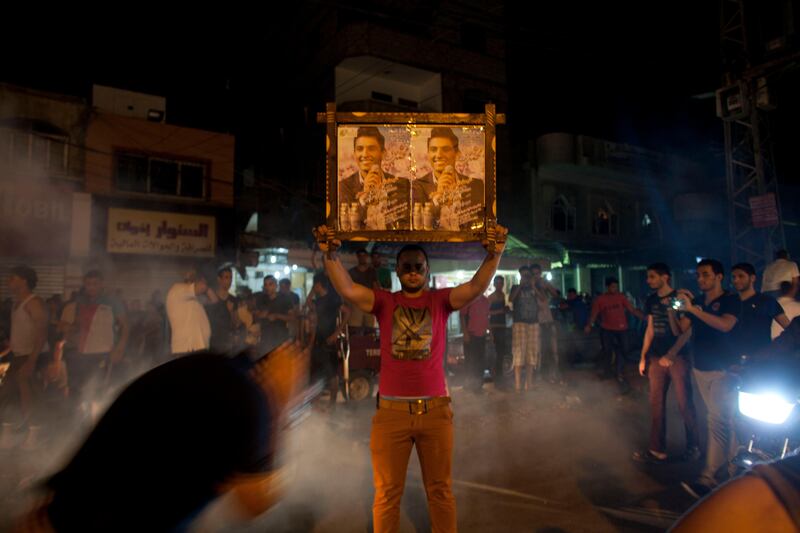 Palestinians react to the news that  Mohammed Assaf is announced the winner of the  regional 'Arab Idol' singing contest held in Beirut , Lebanon June 22,2013 in downtown Gaza City, Gaza .Thousands of Palestinians in Gaza and the West Bank took to the streets to celebrate his victory. (Photo by Heidi Levine/Sipa Press). *** Local Caption ***  IMG_0737.jpg