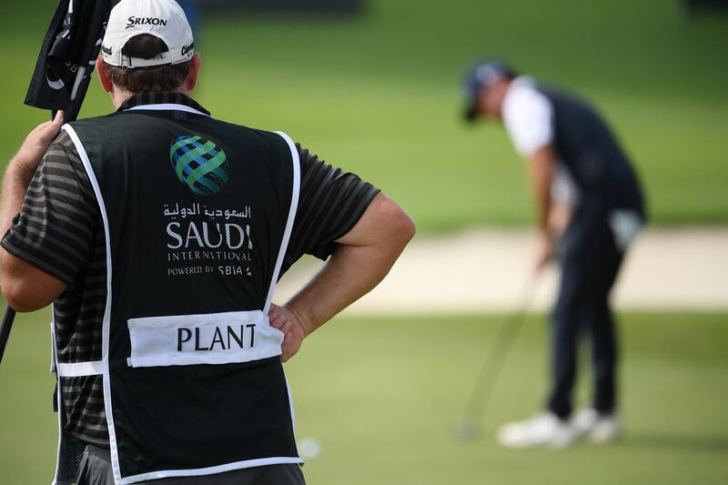 Alfie Plant of England putts on the ninth green while being watched by his caddie in King Abdullah Economic City, Saudi Arabia. Getty Images