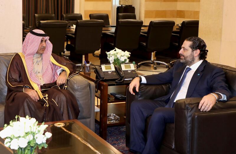 In this photo released by Lebanon's official government photographer Dalati Nohra, Lebanese Prime Minister Saad Hariri, right, meets with Saudi royal court envoy Nizar al-Aloula, at the government palace, in Beirut, Lebanon, Wednesday, Feb. 13, 2019. Saudi Arabiaâ€™s ambassador to Lebanon said the kingdom has lifted a 15-month warning that had advised its citizens not to travel to Beirut. Walid Bukhari made the statement in Beirut on Wednesday following a meeting between al-Aloula and Hariri. (Dalati Nohra via AP)