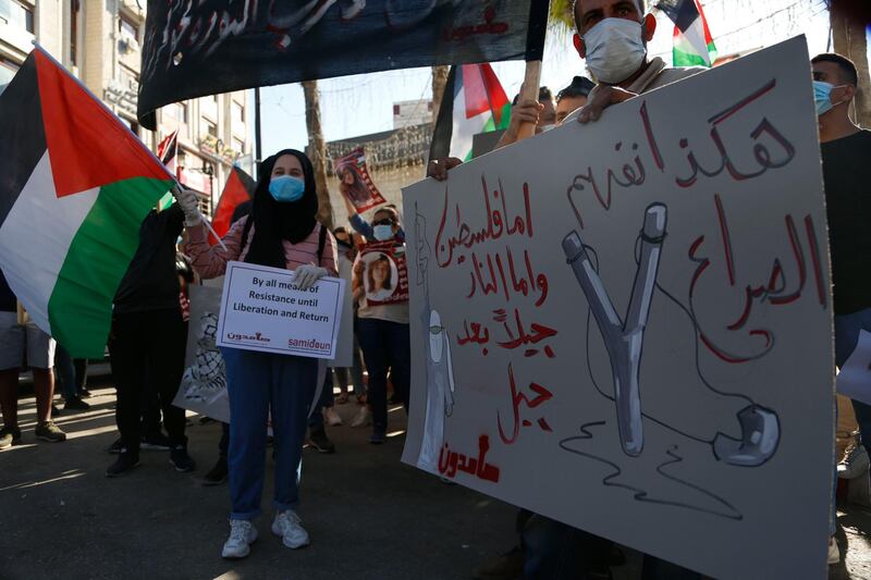 Palestinians demonstrate against Israeli plans for the annexation of parts of the West Bank, in the in the West Bank city of Ramallah. The Arabic reads " This is how we understand conflict, either Palestine, or fire, generation after generation". AP Photo