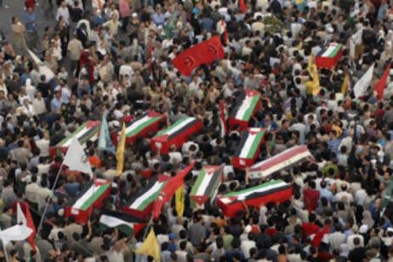 Supporters carry a coffins of 46 Syrian nationals and Palestinians who grew up in refugee camps in Syria, during their funeral at al-Yarmouk Camp near Damascus.