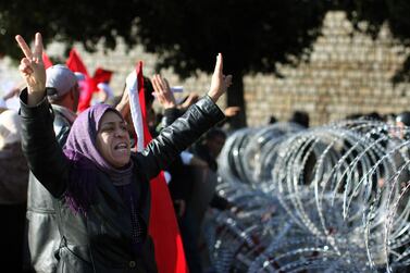 A protester pleads with soldiers to allow her through the wire barricade outside the Tunisian prime minister's office on January 24, 2011 in Tunis. Christopher Furlong / Getty Images