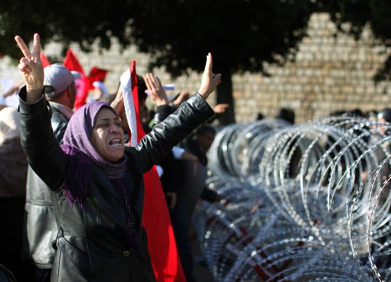 A protester pleads with soldiers to allow her through the wire barricade outside the Tunisian prime minister's office on January 24, 2011 in Tunis. Christopher Furlong / Getty Images