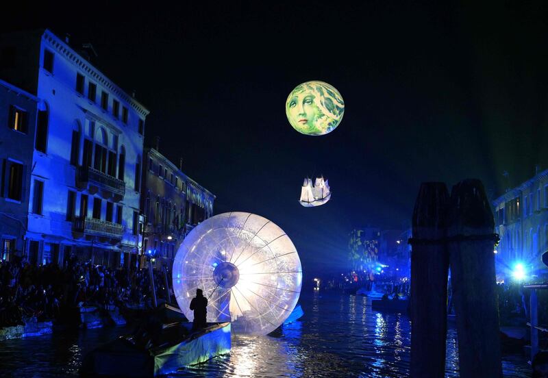 Artist performs during the 'Tutta colpa della Luna' or 'Blame the Moon' festivities down the Rio di Cannaregio, one of Venice's famed canals on February 16, 2019.  Venice began its annual Carnival festivities with a floating, night-time parade starting more than two weeks of celebrations to mark 50 years since man first walked on the moon. / AFP / Vincenzo PINTO
