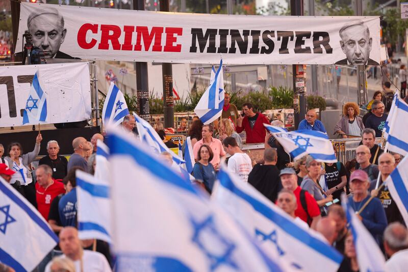 Israeli activists wave national flags and hold placards during an anti-government demonstration in Tel Aviv. AFP