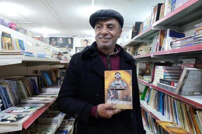 Hussein Yassin, owner of Azbekeye bookshop, holds a copy of his own book. Amy McConaghy / The National