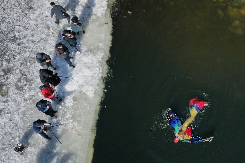 A woman dressed as a mermaid swims in a partly frozen lake in Shenyang, in China's Liaoning province. AFP