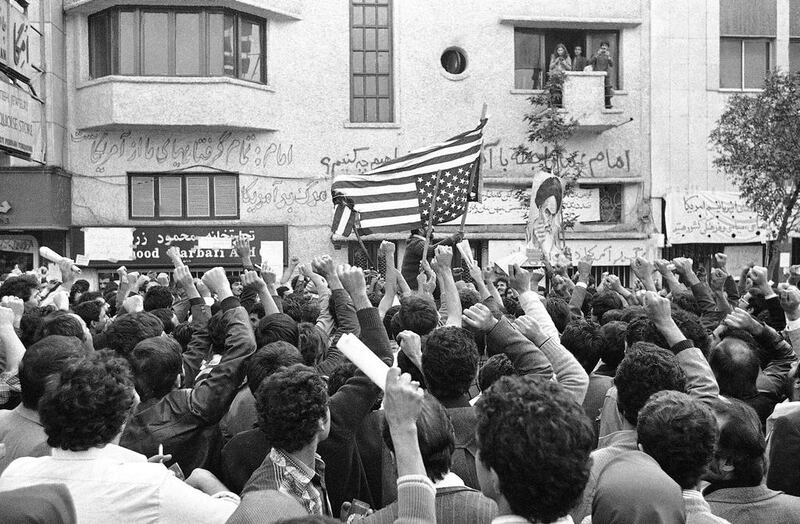 Iranian students hold raised fists in the air and set fire to an American flag on Monday, November 5, 1979 a day after the occupation of the American Embassy in Tehran.  AP