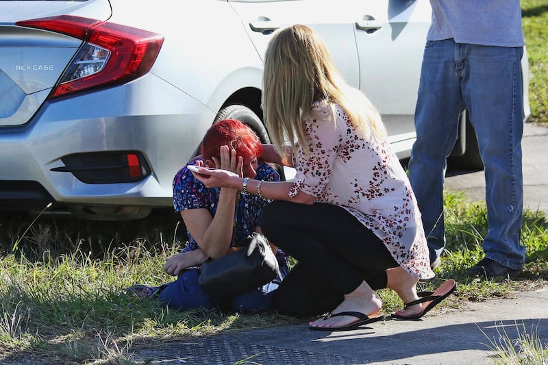 A woman consoles another as parents wait for news regarding a shooting at Marjory Stoneman Douglas High School in Parkland, Fla., Wednesday, Feb. 14, 2018. A shooter opened fire at the Florida high school Wednesday, killing people, sending students running out into the streets and SWAT team members swarming in before authorities took the shooter into custody. (AP Photo/Joel Auerbach)