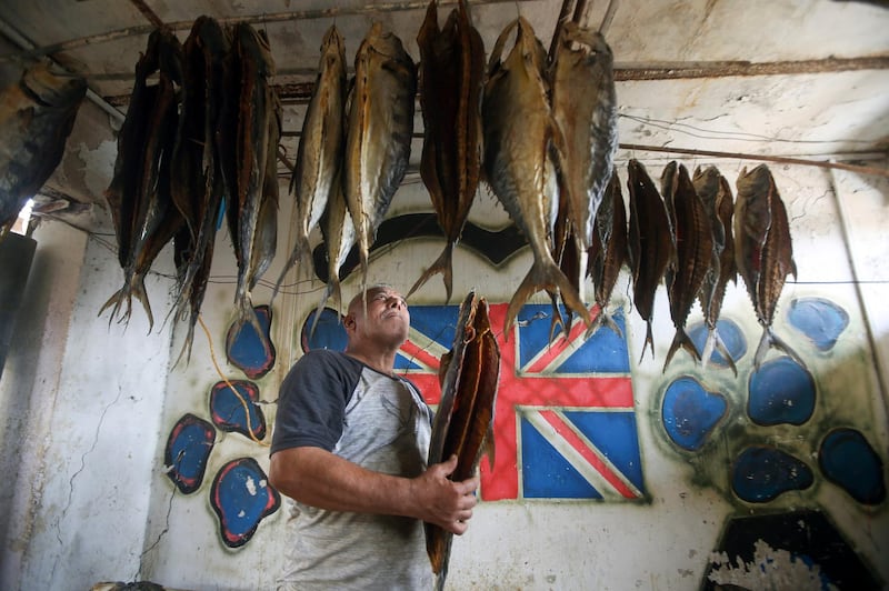 A man examines masmouta hanging from a ceiling, ready to be sold at market for Eid. Reuters