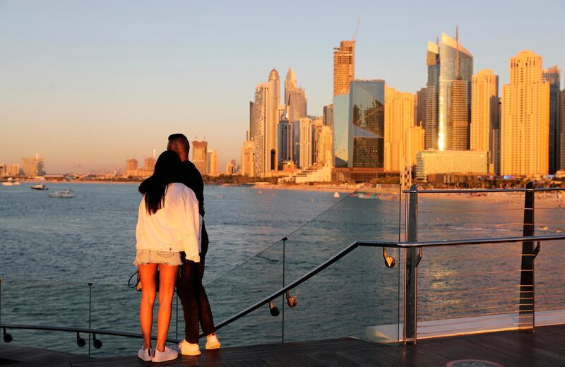 Tourists look at the skyline at sunset. AP