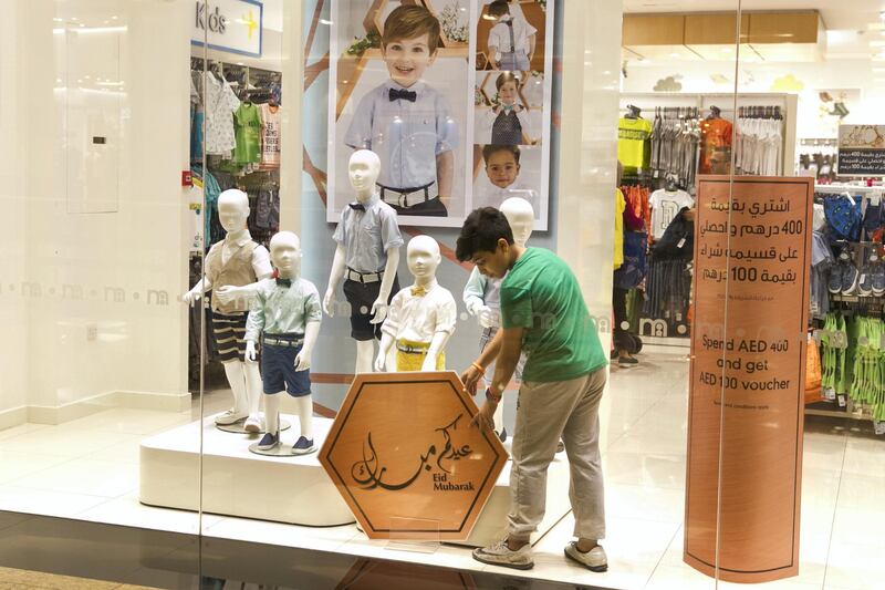 DUBAI, UNITED ARAB EMIRATES - JUNE 13, 2018. 

A young boy adjusts a Eid Mubarak sign at Mall of the Emirates on the 28th day of Ramadan.

(Photo by Reem Mohammed/The National)

Reporter: 
Section: NA

